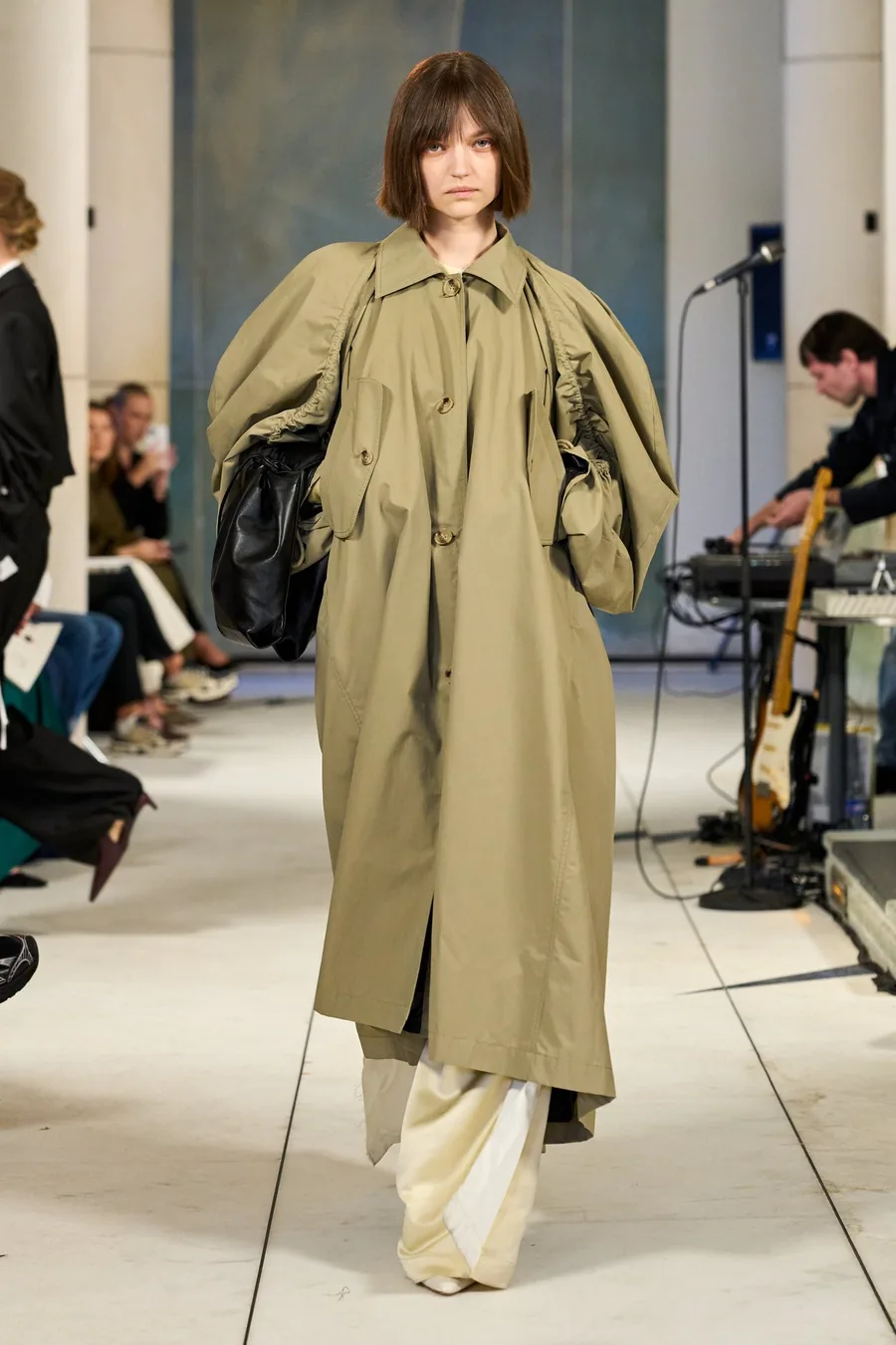 SHOWstudio, Litkovska S/S 27 STRICHA: modelo con un abrigo largo caqui de mangas voluminosas