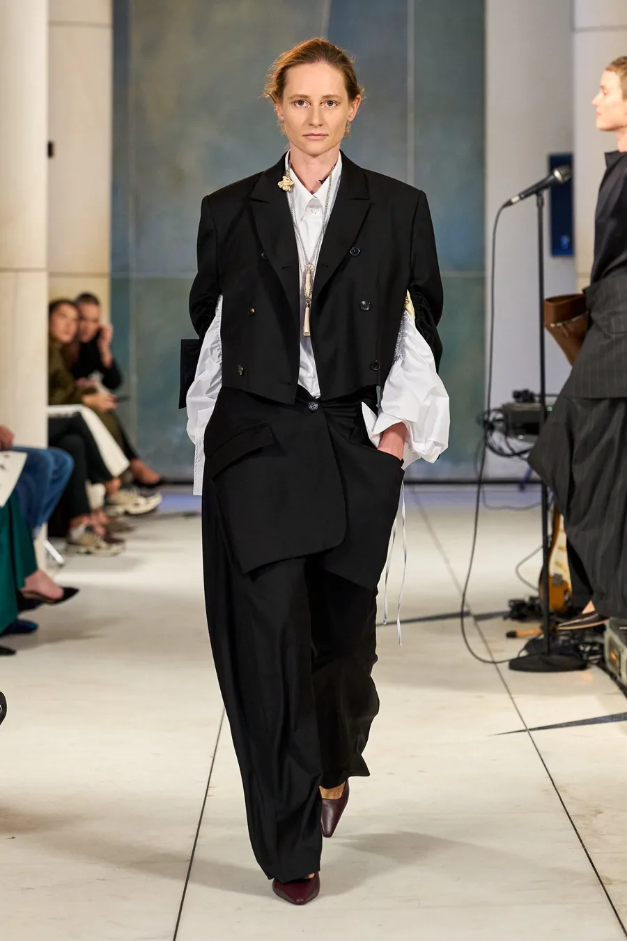 SHOWstudio, Litkovska S/S 27 STRICHA: modelo con traje negro y camisa blanca en la pasarela
